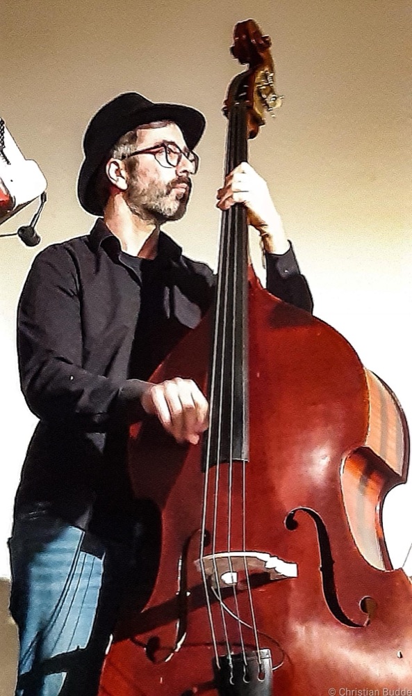 Felix Lein mit Brille und Hut spielt Kontrabass